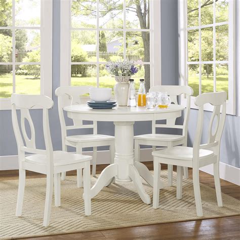 A Dining Room Table With White Chairs And An Art Print On The Wall Above It