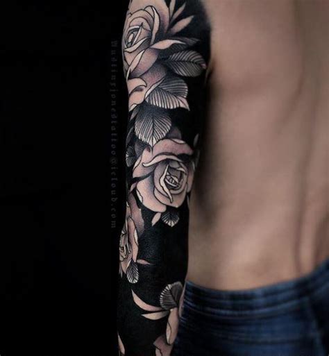 A Man With A Rose And Skull Tattoo On His Arm