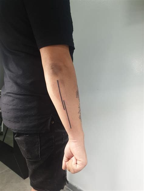 A Man With A Tattoo On His Arm Is Holding The Hand Of Another Person