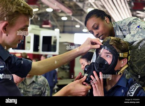 A Royal Air Force Cadet Assists His Fellow Cadet Try On Gear Provided