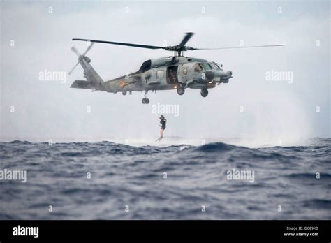 A Us Navy Search And Rescue Swimmer Jumps Into The Ocean From An Sh 60R