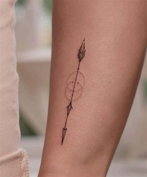 A Woman S Arm With An Arrow And Arrows Tattoo On The Left Side Of Her Arm