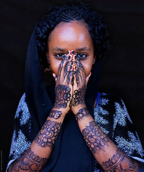 A Woman S Hands With Henna Tattoos On Her Arm And Hand While She Is