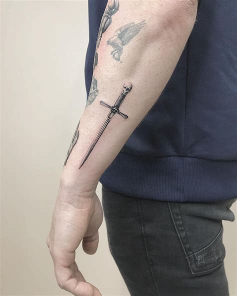 Sword Tattoo On The Left Forearm