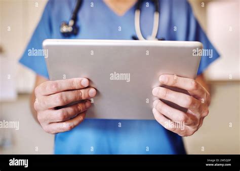 Things Just Got A Whole Lot Easier An Unrecognizable Doctor Using His Tablet In His Office