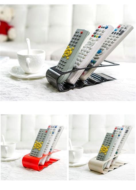 Three Remote Controls Sitting On Top Of A Table Next To A Cup And Saucer